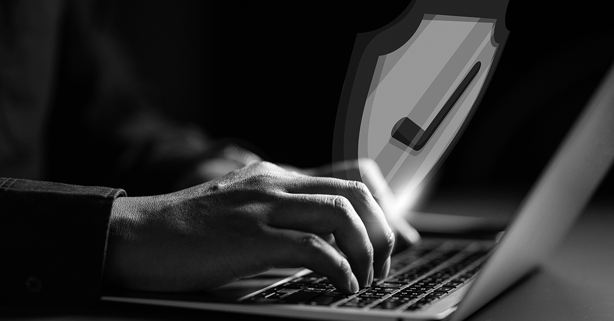 man writing on laptop with shield and ok icon